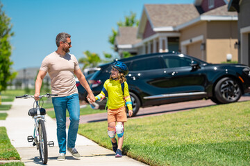 Obraz premium Happy Fathers day. Father and son on the bicycle. Father and son riding a bike in summer park. Kid learning to riding bicycle. Father and son riding bikes wearing helmets. Child on bicycle outdoor.