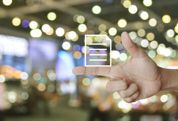 Document icon on finger over blur light and shadow of shopping mall, Technology communication concept