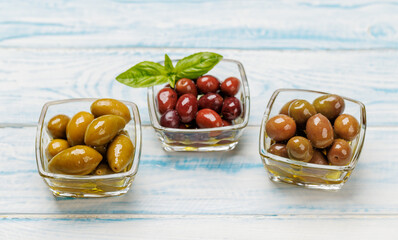 An assortment of various olives presented in a bowl, showcasing different colors, textures, and...