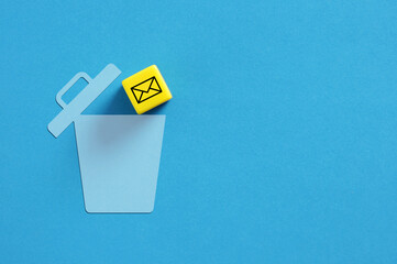 Yellow cube with email symbol falling into blue trash can