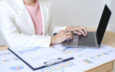 Asian businesswoman sit at their desks and calculate financial graphs showing results about their investments and plan successful business growth process