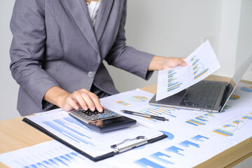 Asian businesswoman sit at their desks and calculate financial graphs showing results about their investments and plan successful business growth process