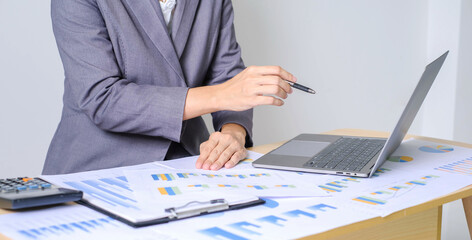 Asian businesswoman sit at their desks and calculate financial graphs showing results about their investments and plan successful business growth process
