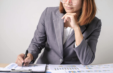 Asian businesswoman sit at their desks and calculate financial graphs showing results about their...