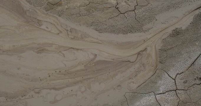 Muddy Vulcanos located in Buzau County, Romania, a National Landmark, Gas bubbles coming out a mud volcano. Paclele mici and Paclele Mari