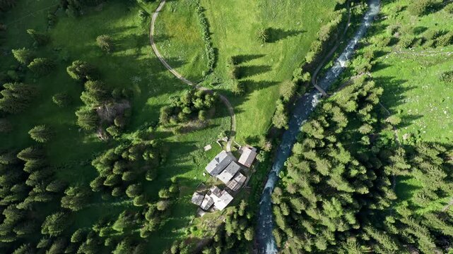 Cascate del rutor surrounded by lush green forest and river, aerial view
