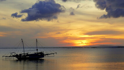Herrlich warmer Sonnenuntergang mit großem Fischerbootbei bei Nembrala in Westtimor auf der Insel...