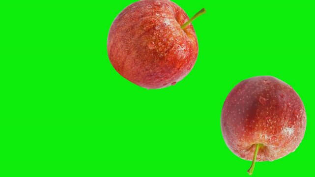 Red apples falling on green screen