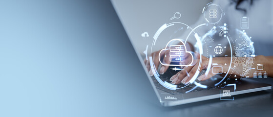 Hands typing on laptop with digital cloud storage icons overlay.