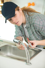 a woman fixing kitchen sink