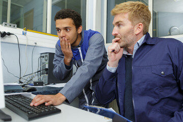 worried engineers working with computer indoors