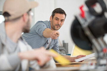 student and teacher in carpentry class using circular saw