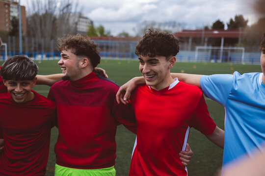 Smiling soccer players standing together on field