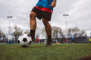 Soccer player kicking ball on field