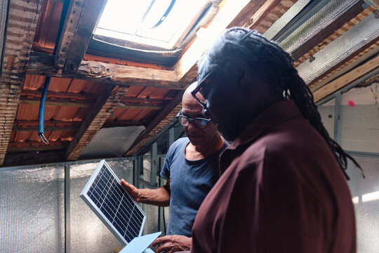 Architect and builder having discussion over solar panel at site