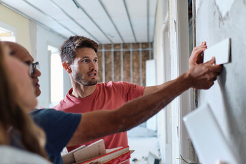 Man and woman discussing over samples with construction worker at site