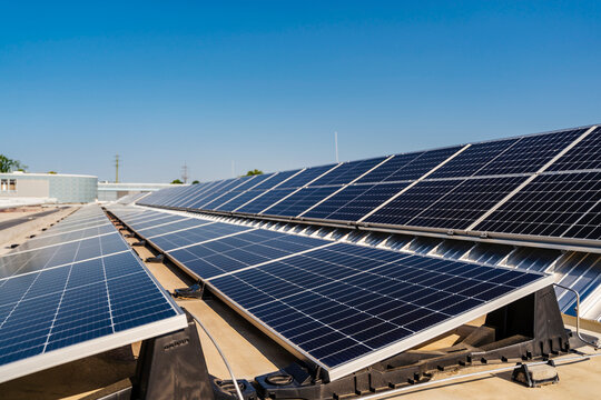 Solar panels installed on a rooftop, harnessing clean energy from the bright blue sky above.