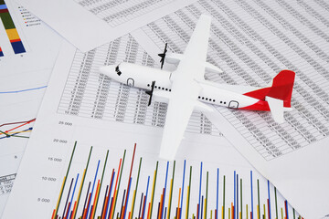Airplane model on financial reports background 