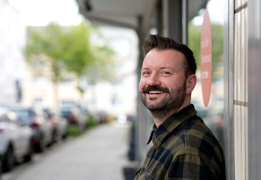 Cheerful businessmen in flannel shirt at street