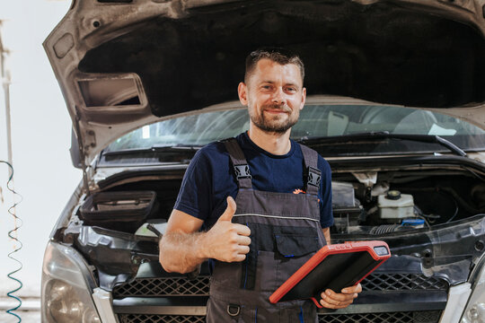 Mechanic gesturing thumps up in garage