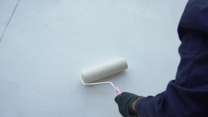 Close up of painter hand holding brush painting white wall. Home painting and decorating concept. House for sale or real estate.