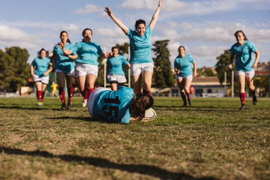 Cheerful rugby players winning match on sunny day