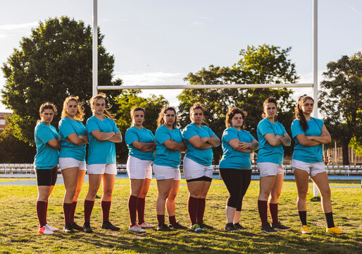 Athletes standing together with arms crossed on field