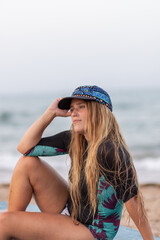 Pensive woman sitting on SUP board on beach