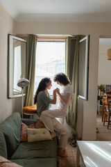 Obraz premium Cheerful couple of lesbian women in love at home