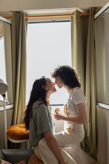 Cheerful couple of lesbian women in love at home