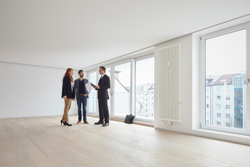 Young couple discussing with real estate agent at new property