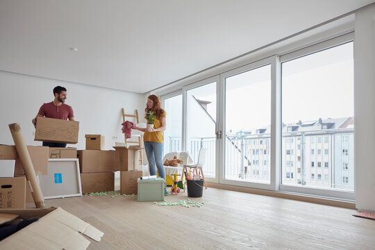 Young couple unpacking boxes in new apartment