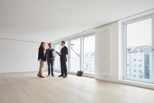 Young couple discussing with real estate agent at new property - Powered by Adobe