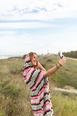 Cheerful woman taking selfie in nature