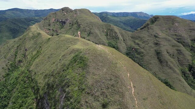 Aerial descends to lone hiker on summit ridge trail, Codo de los Andes