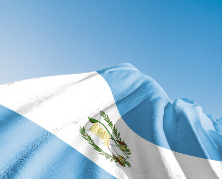 Guatemala national flag cloth fabric waving on beautiful sky blue Background.