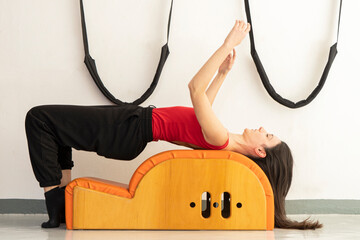 Woman practicing pilates on special equipment at a gym