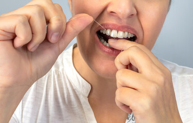 Anonymous close-up image of a person flossing their teeth, emphasizing the importance of dental...