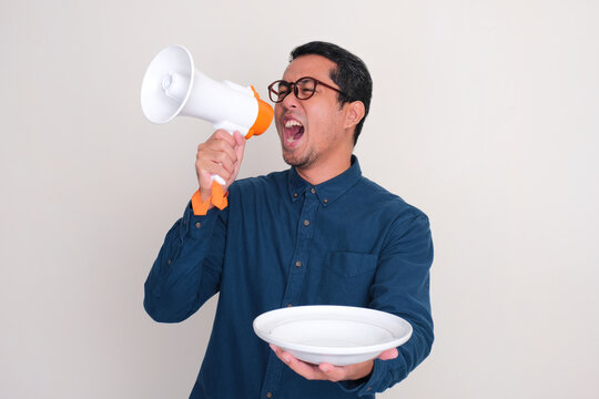 A man screaming through megaphone while showing empty dinning plate
