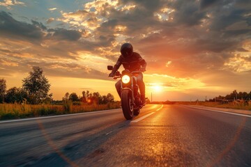 A person riding a motorcycle along a winding road at sunset