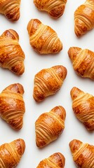 Freshly baked croissants forming a pattern on white background