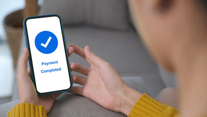 Hand holding smart phone with payment completed on screen, online banking, shopping online, cashless transaction