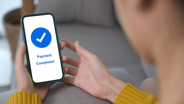 Hand holding smart phone with payment completed on screen, online banking, shopping online, cashless transaction