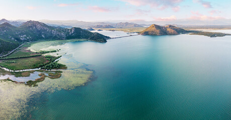 Aerial view of Lake Skadar surrounded by mountains and lush forests in Montenegro