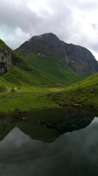The serene beauty of a Mountain reflecting in tranquil waters, surrounded by lush greenery in Norway. A perfect destination for nature lovers seeking adventure and peace near Urke Stavbergsetra