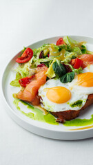 Breakfast, two eggs served on toasted bread with a green herb sauce. Accompanied fresh salad, cherry tomatoes, and smoked salmon slices, all elegantly presented on a white plate and white background