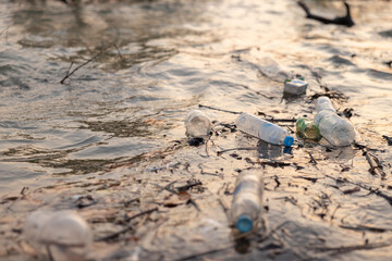 A body of water is covered in plastic bottles and other trash. water pollution concept.