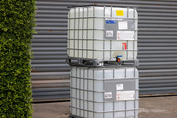 Two large white IBC plastic containers stacked on top of each other
