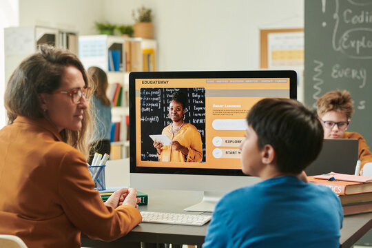 Sde view portrait of female teacher explaining smart learning course to student focus on computer screen