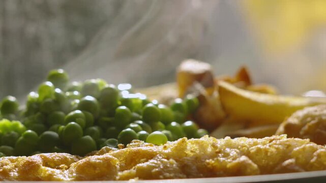 Slow Motion Steam Rising from Hot Fish and Chips Dinner with Garden Peas Ready to Eat 4K